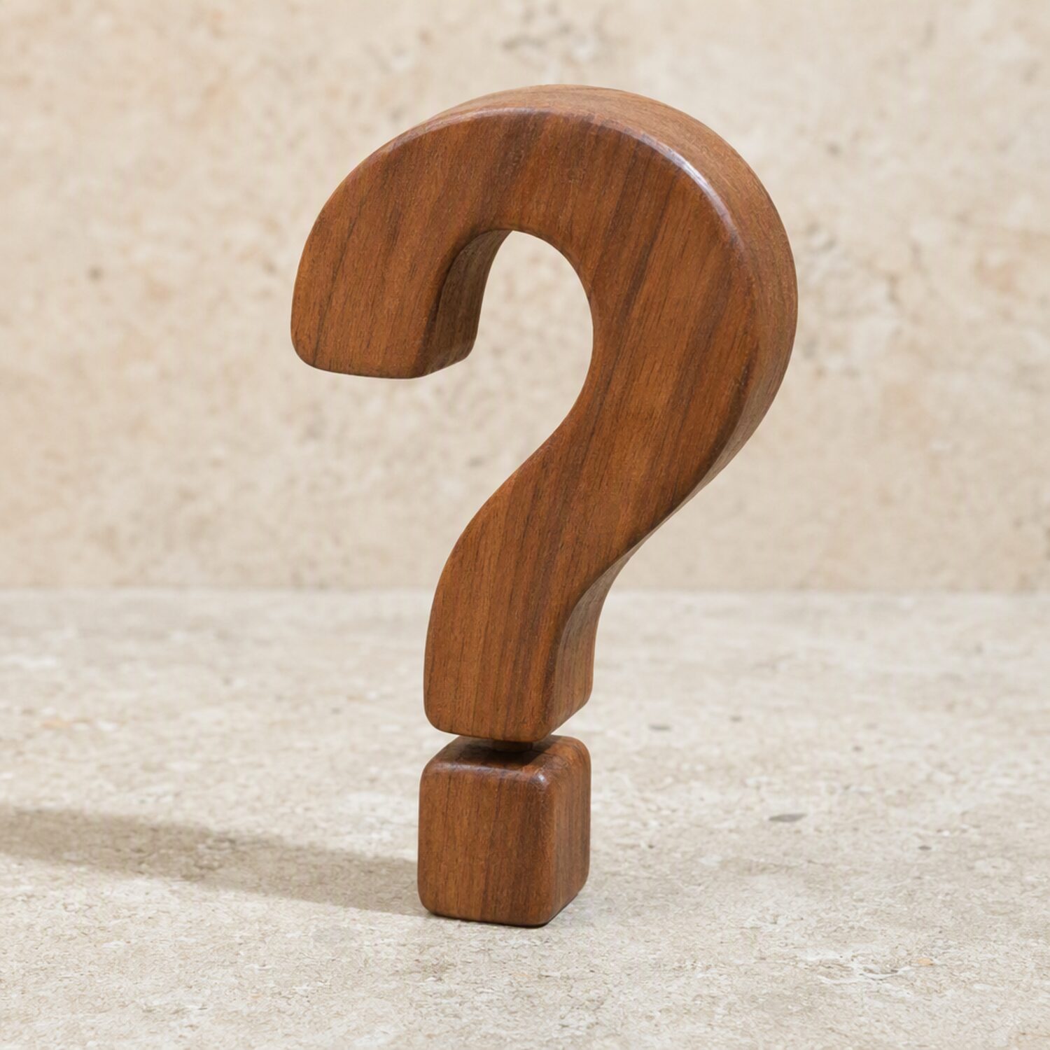 A wooden question mark standing on pale stone