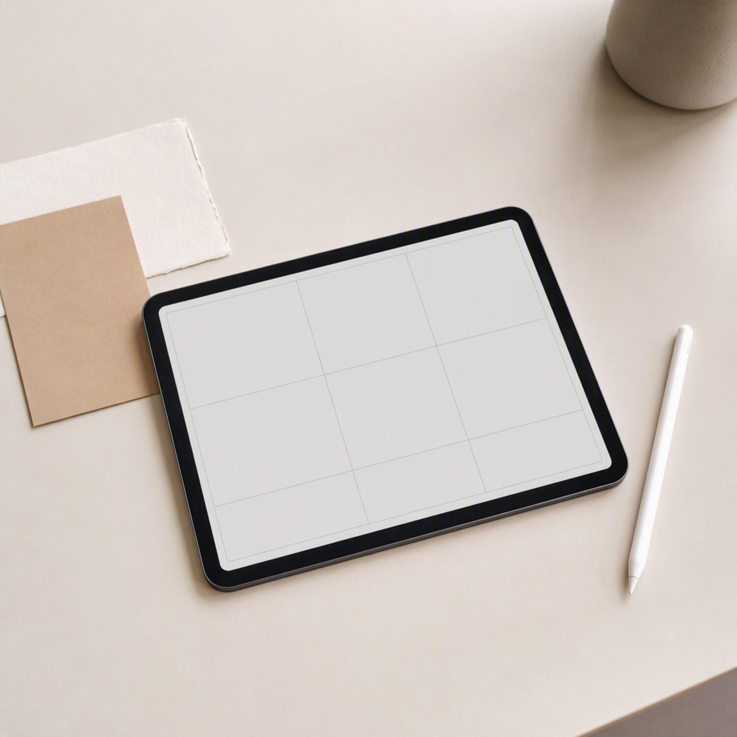 A tablet showing a blank layout grid with a stylus