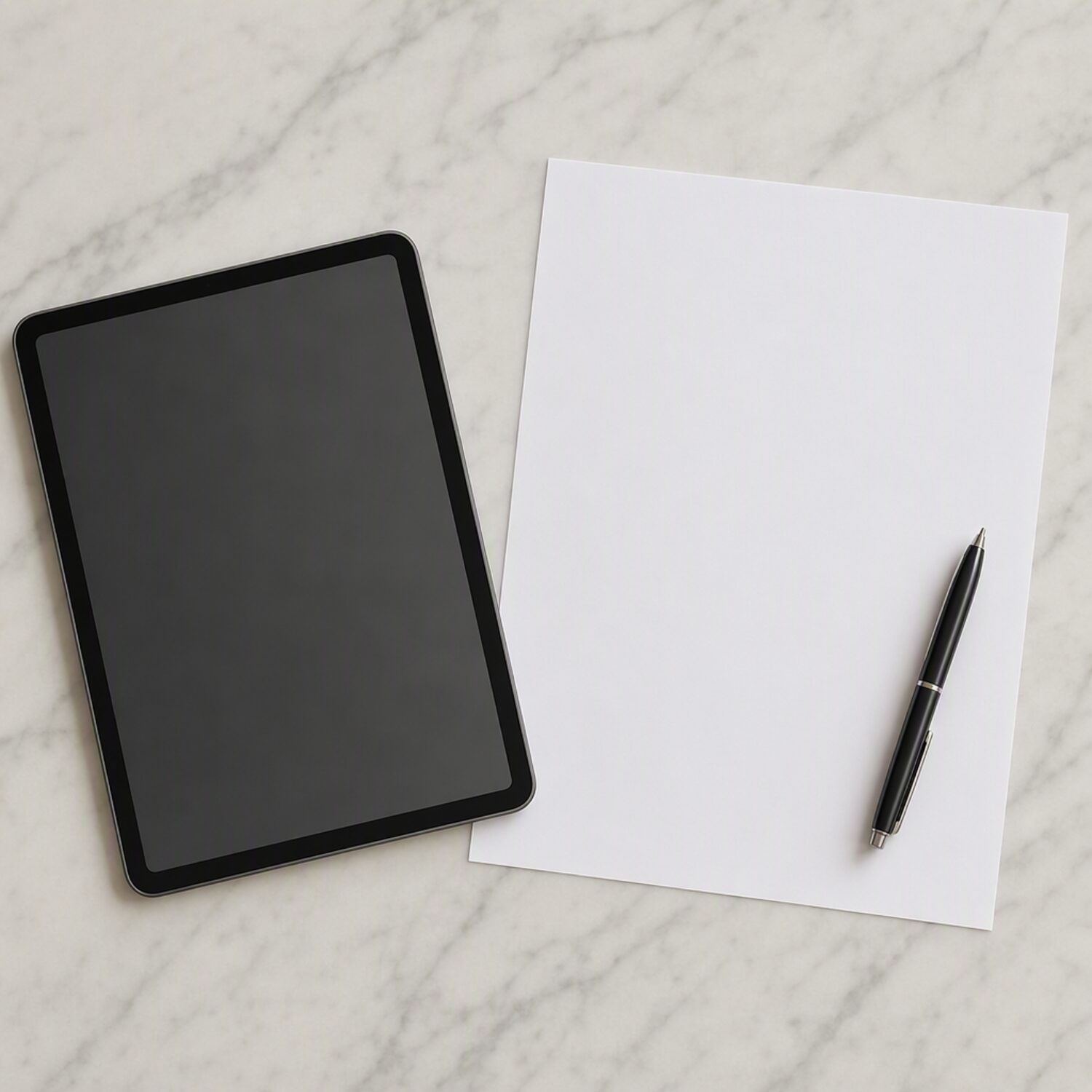 A tablet and printed page on a marble surface