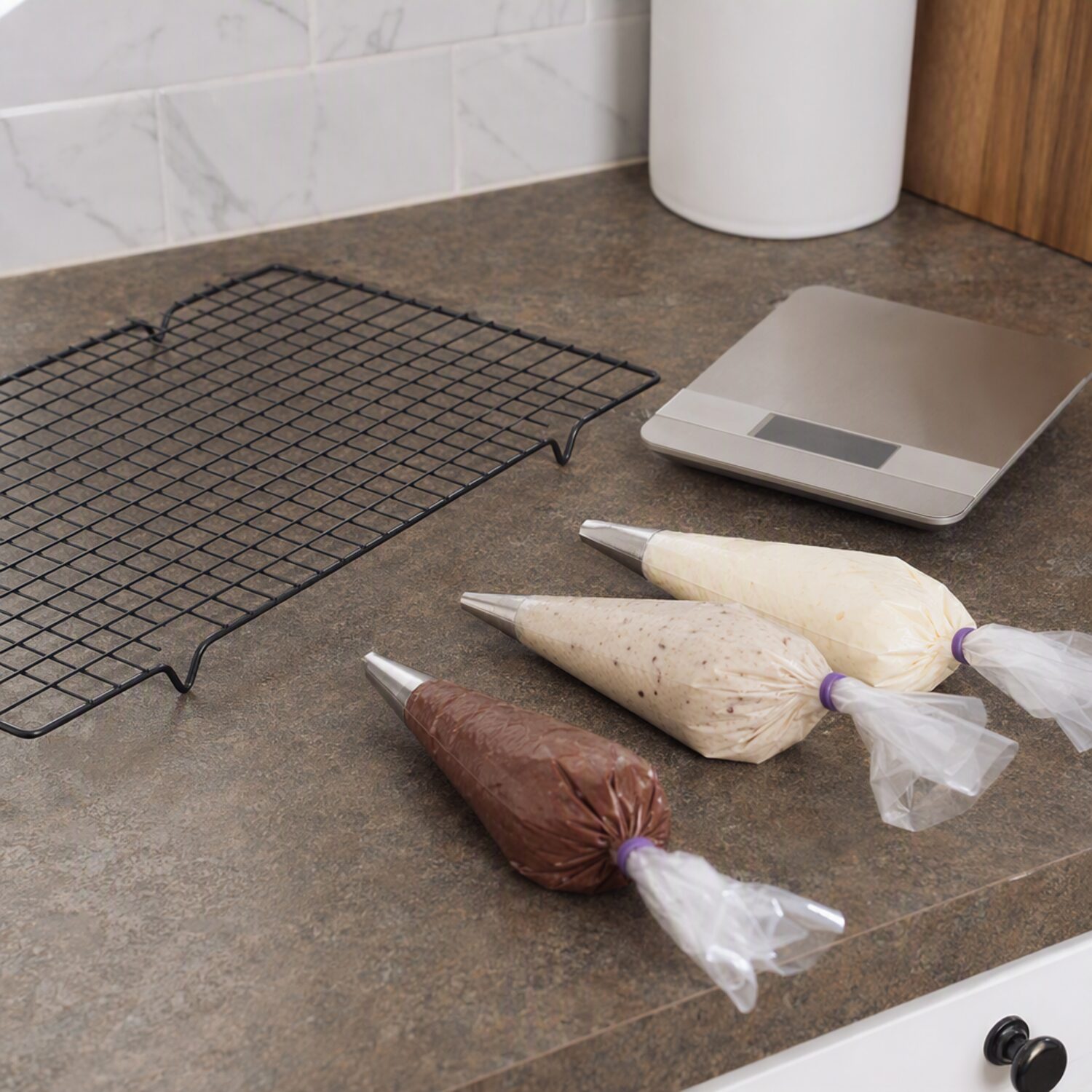 A cooling rack and piping bags on a worktop