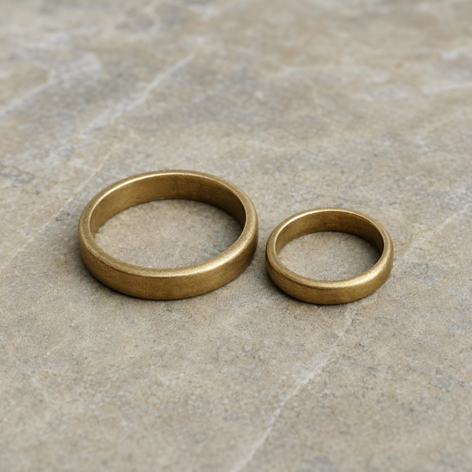Two brass rings on pale stone