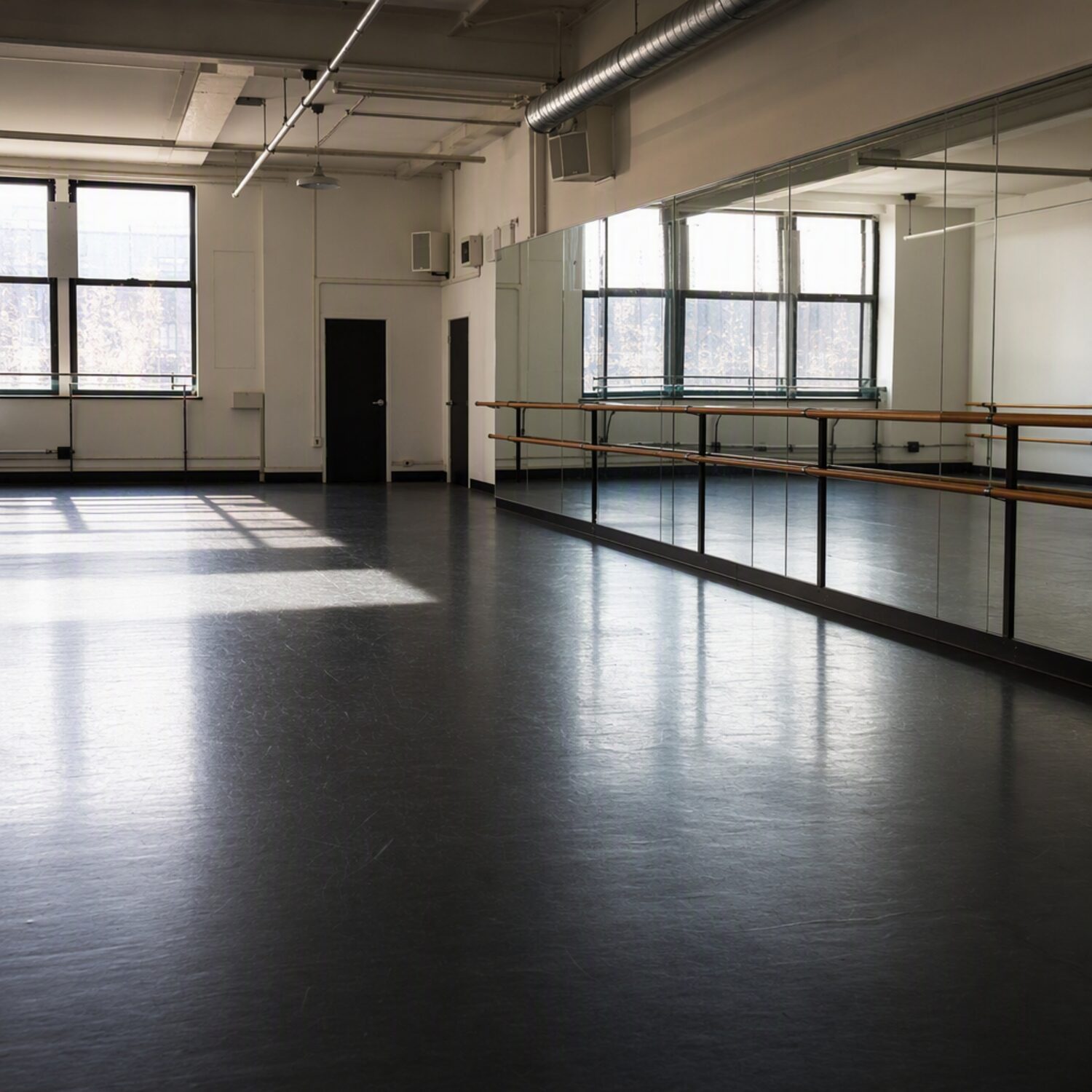 An empty dance studio with a mirrored wall