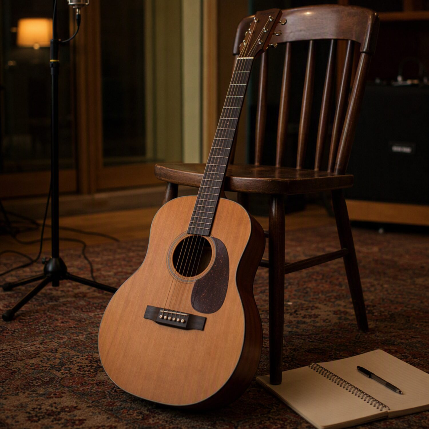 A guitar leaning beside a notebook and mic stand