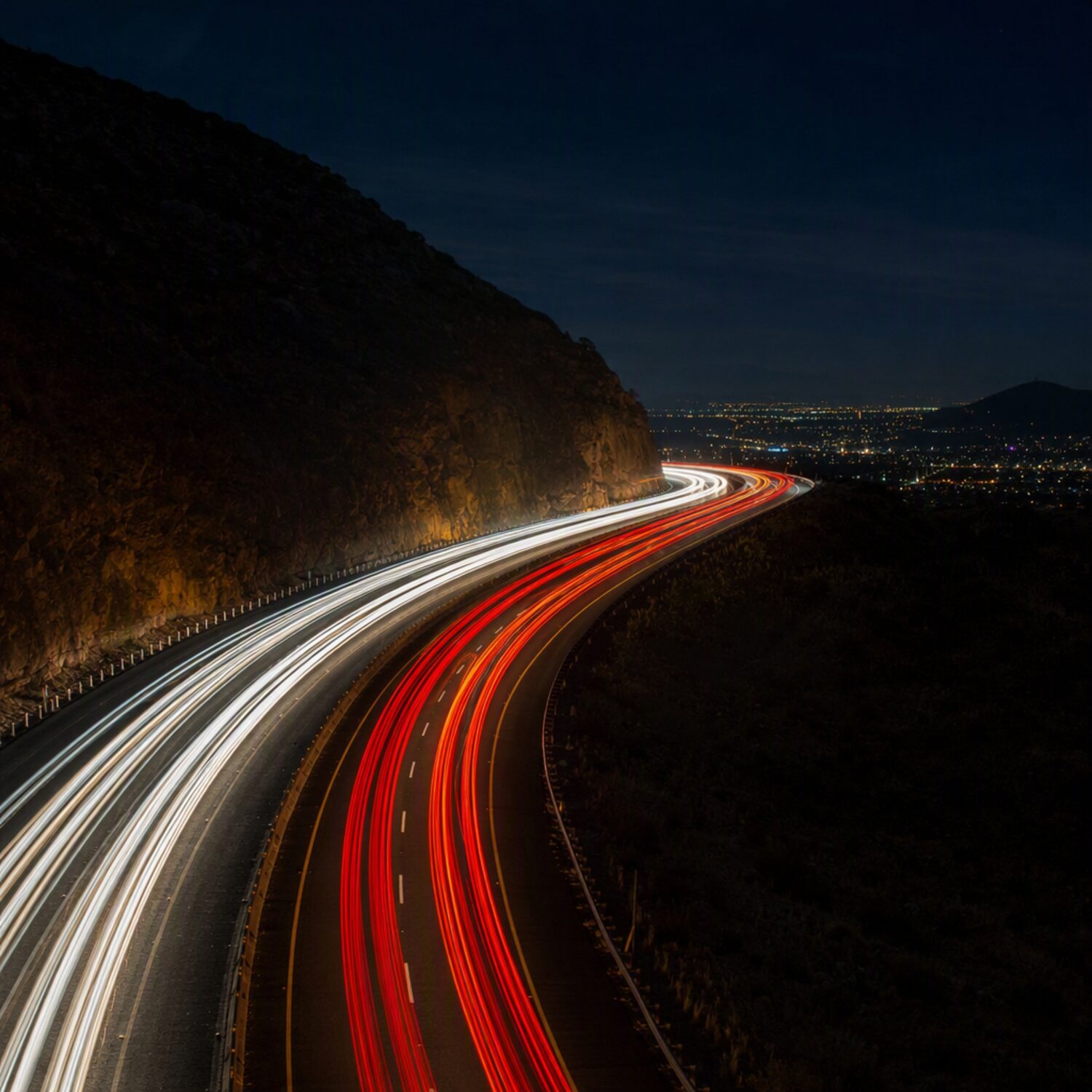 Light trails curving along a night road