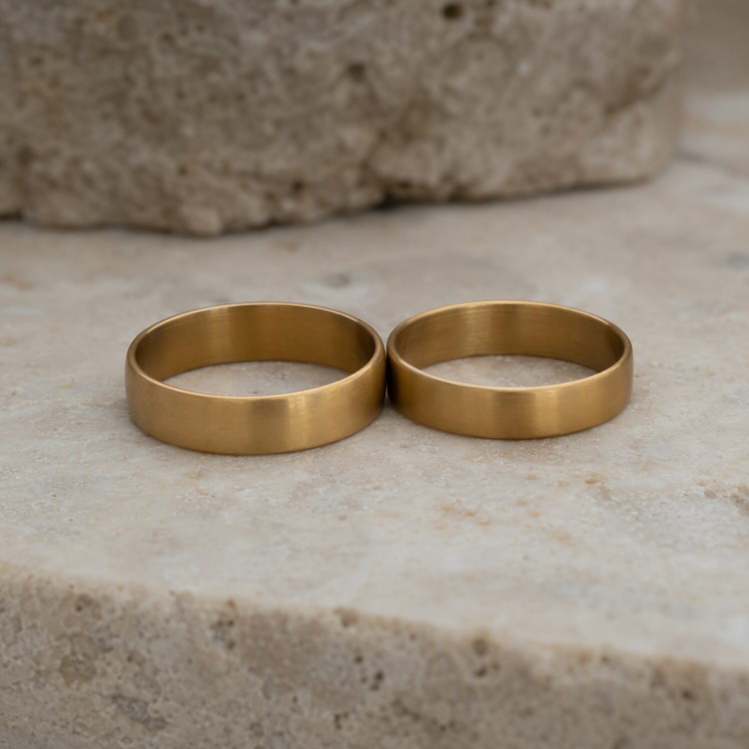 Two brass rings on pale stone