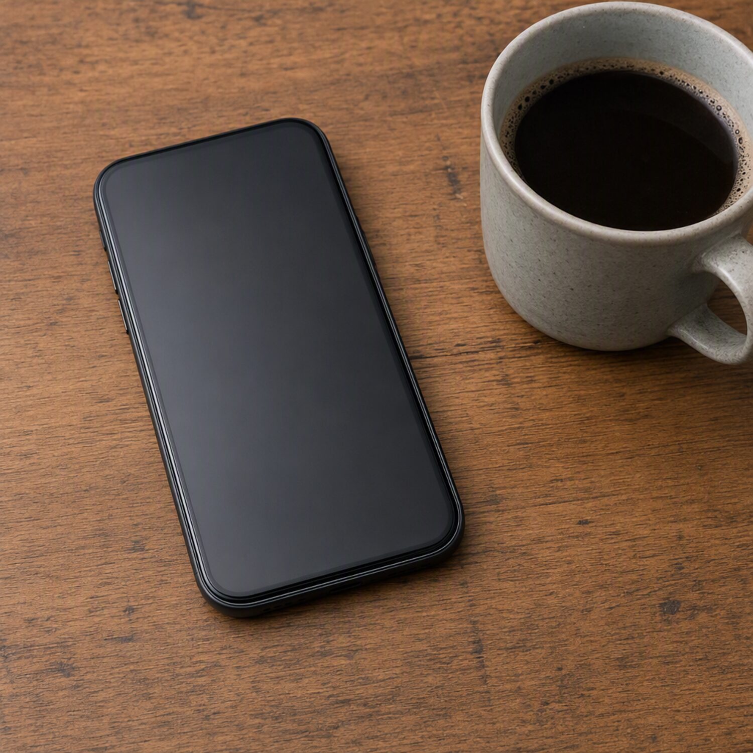 A phone face up beside coffee