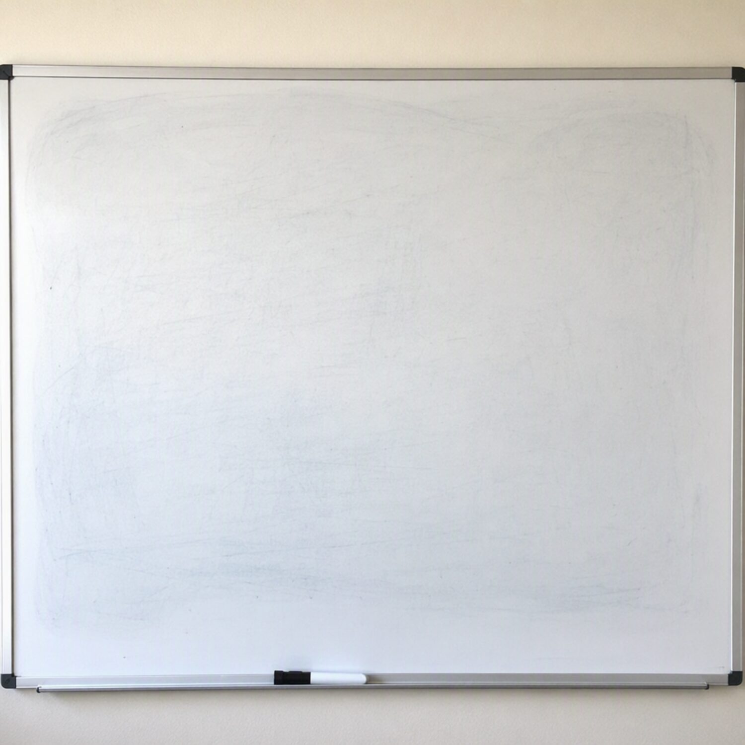 A whiteboard with a marker on the ledge