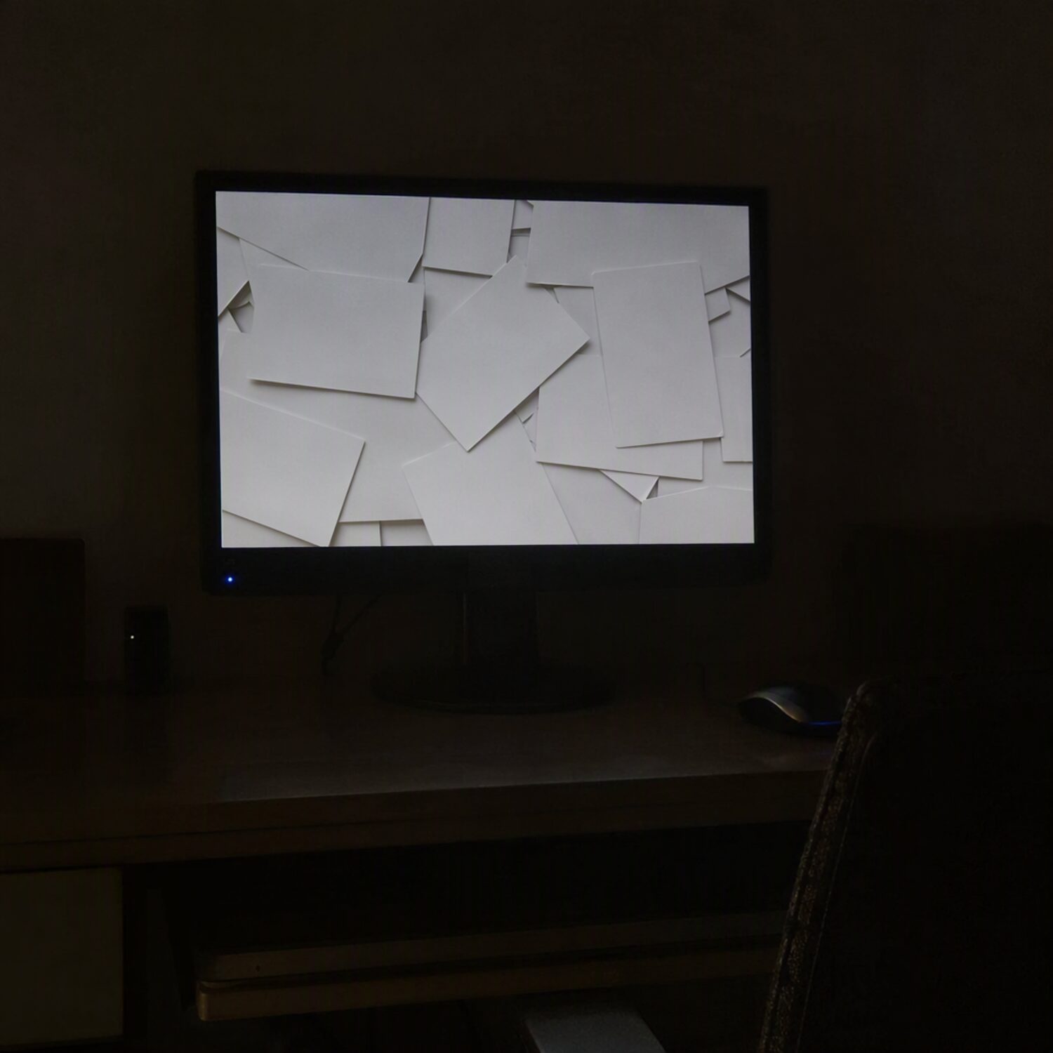 A monitor showing an abstract feed in a dim room