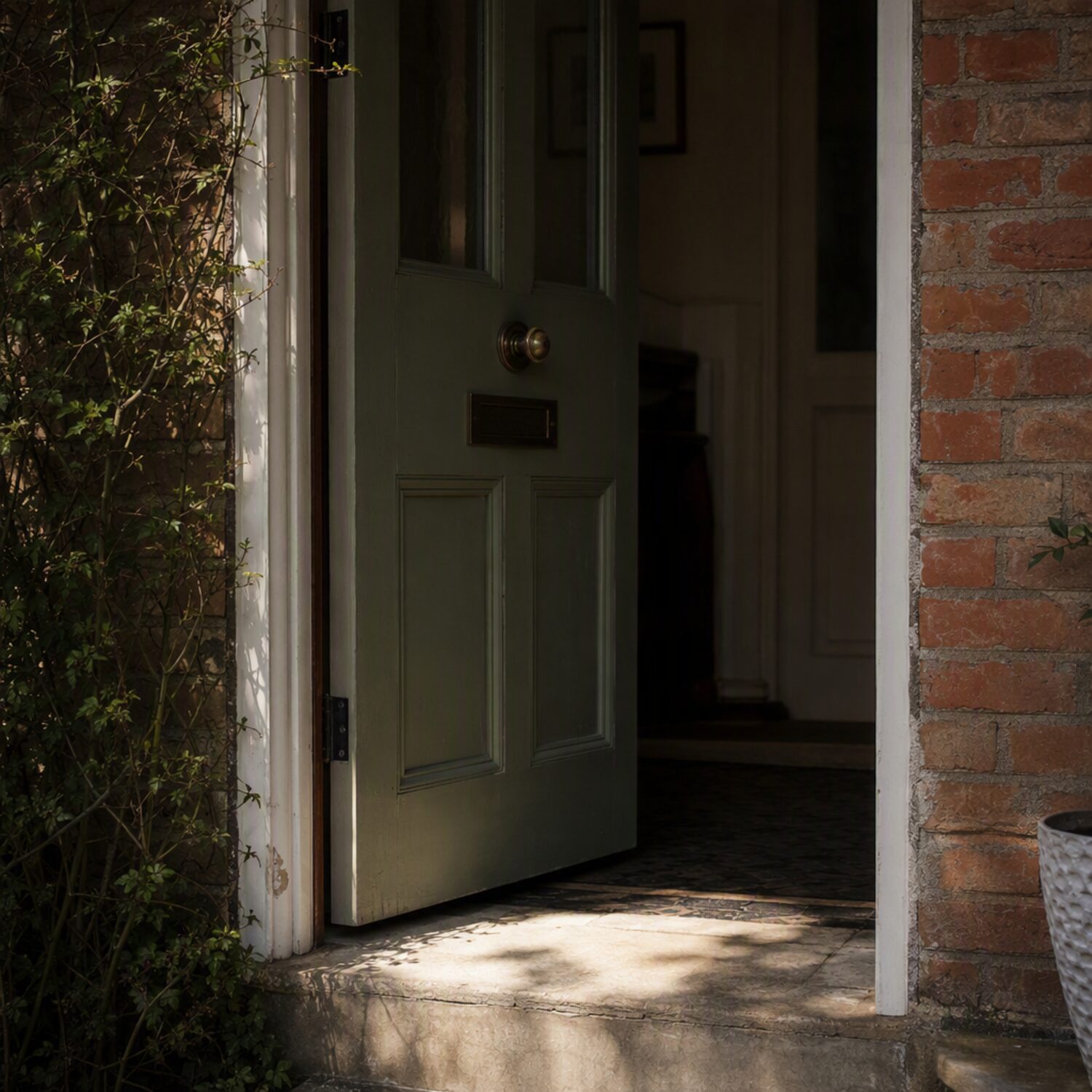 A front door ajar with light on the step