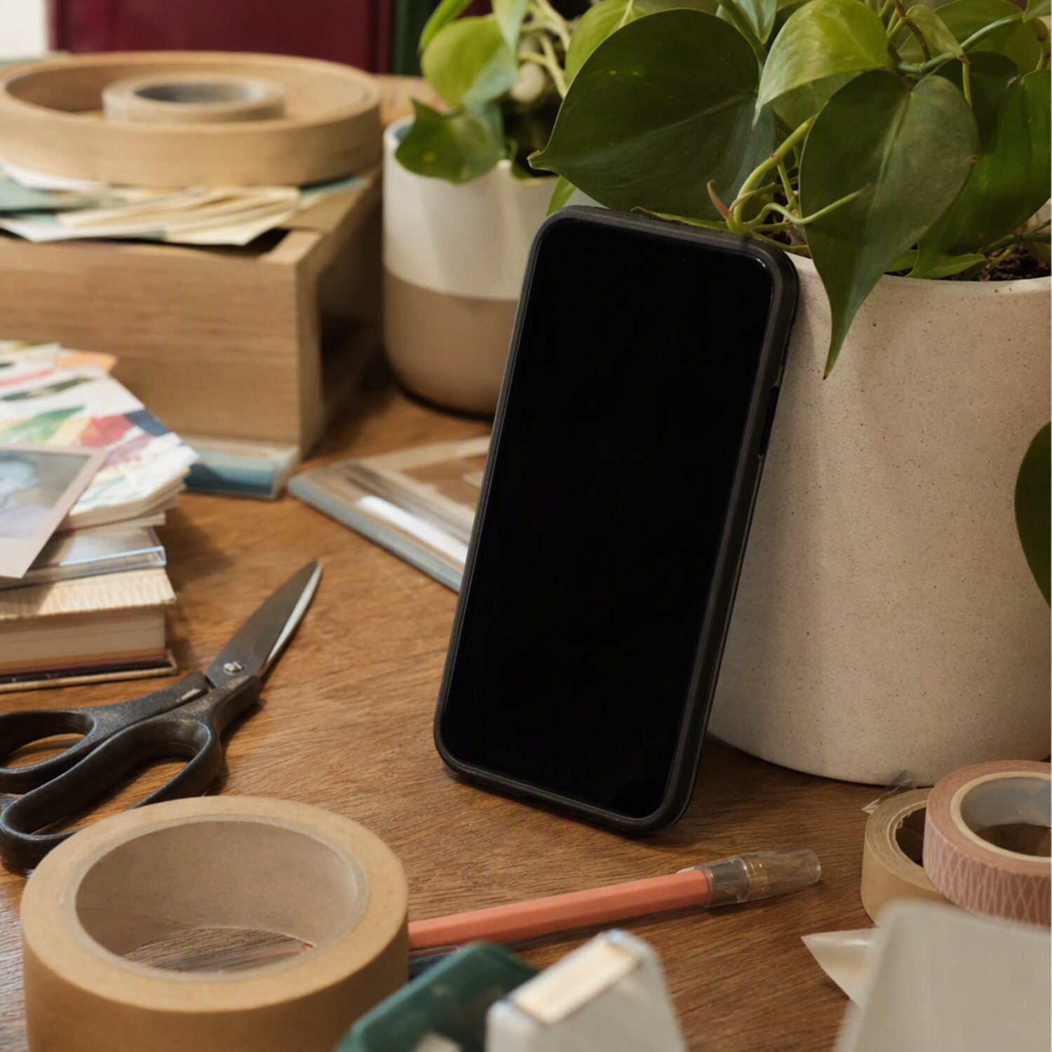 A phone propped on a craft table