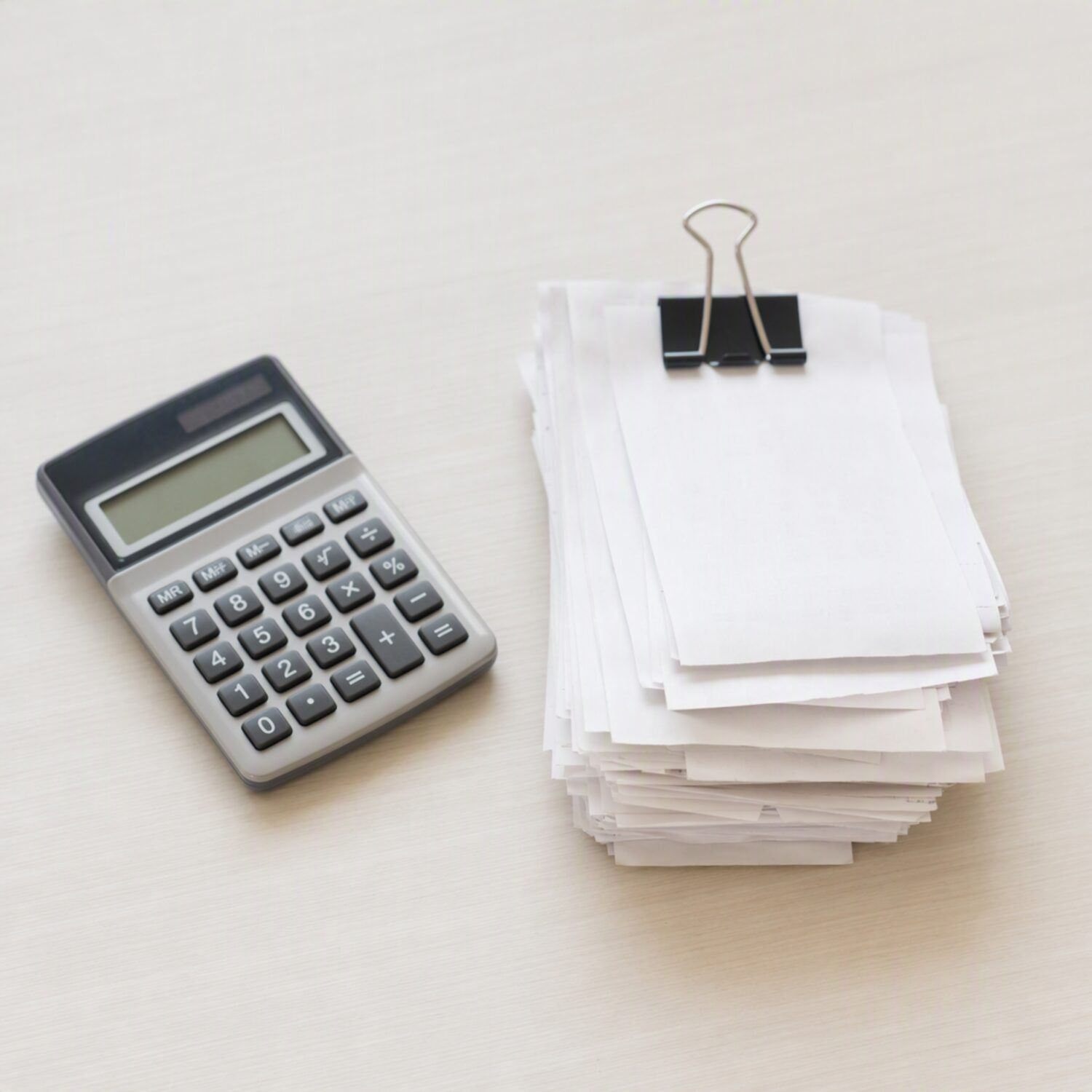 A calculator and clipped receipts on a desk