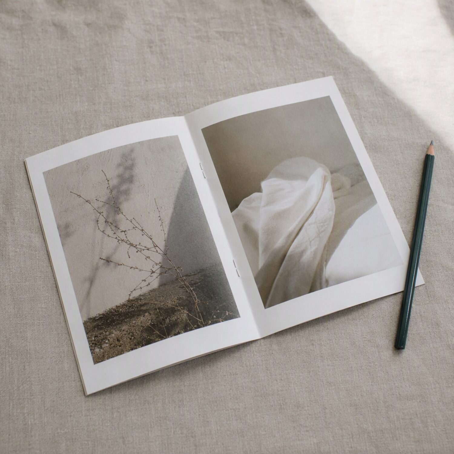 An open printed booklet beside a pencil