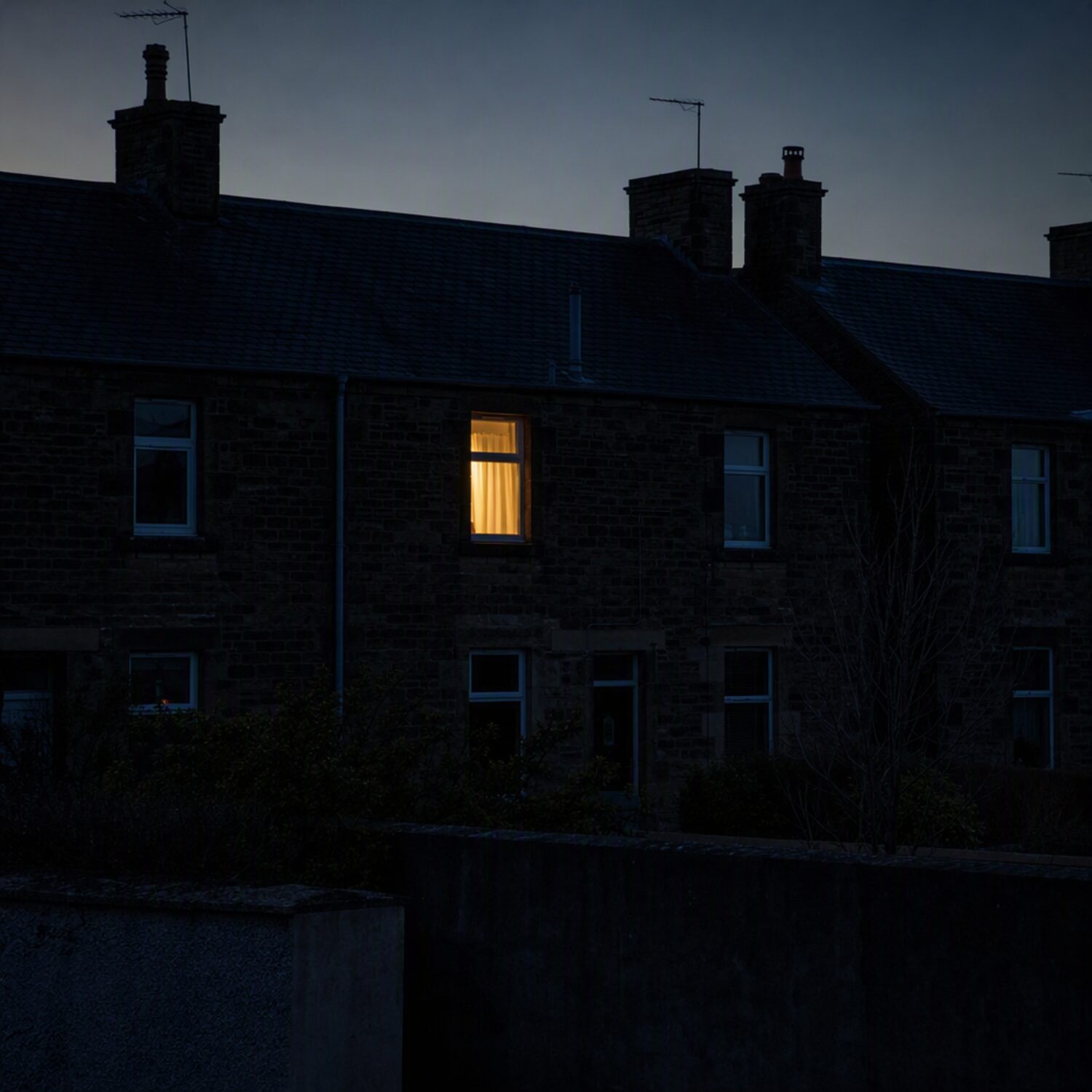 A single lit window in a dark terrace