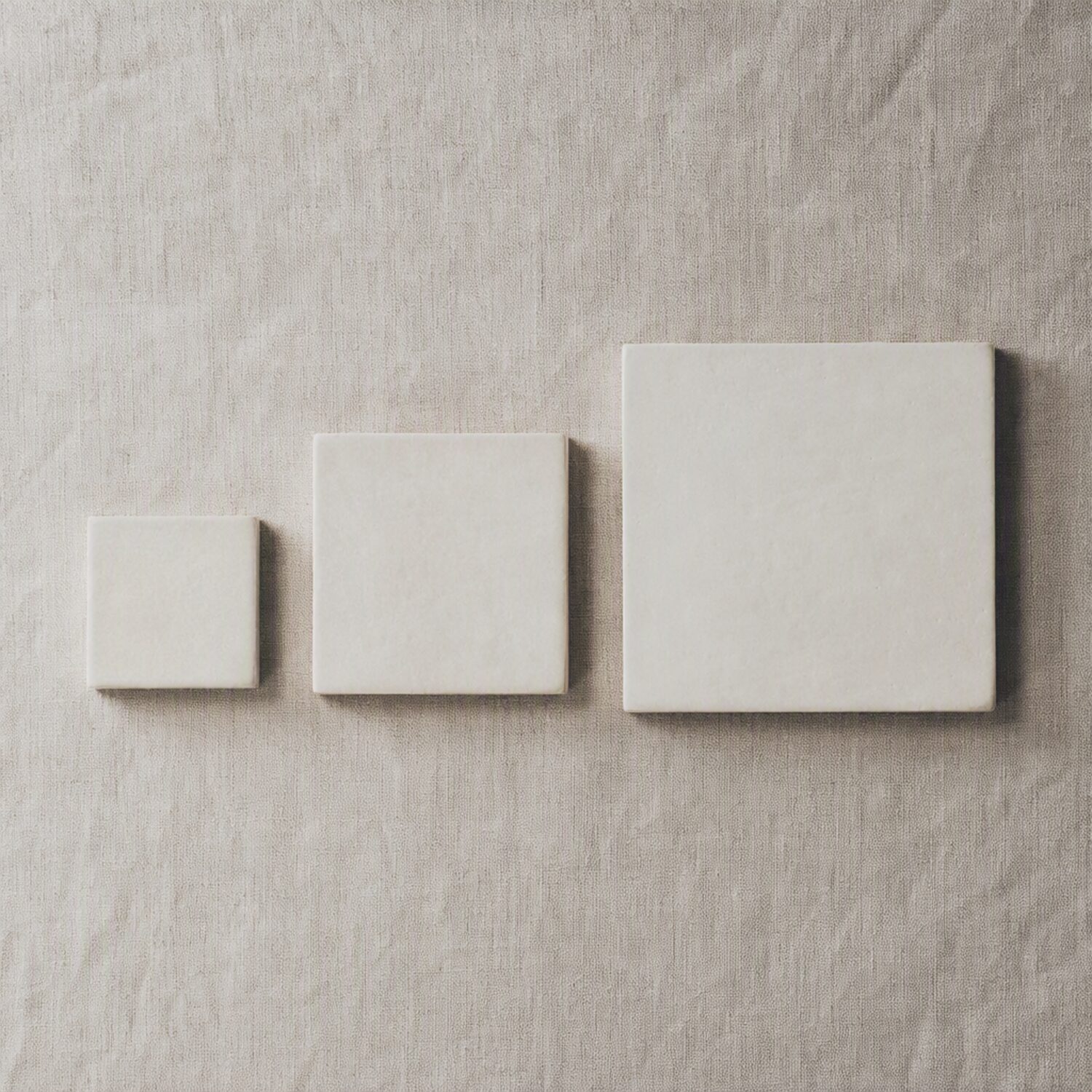 Three ceramic tiles of increasing size