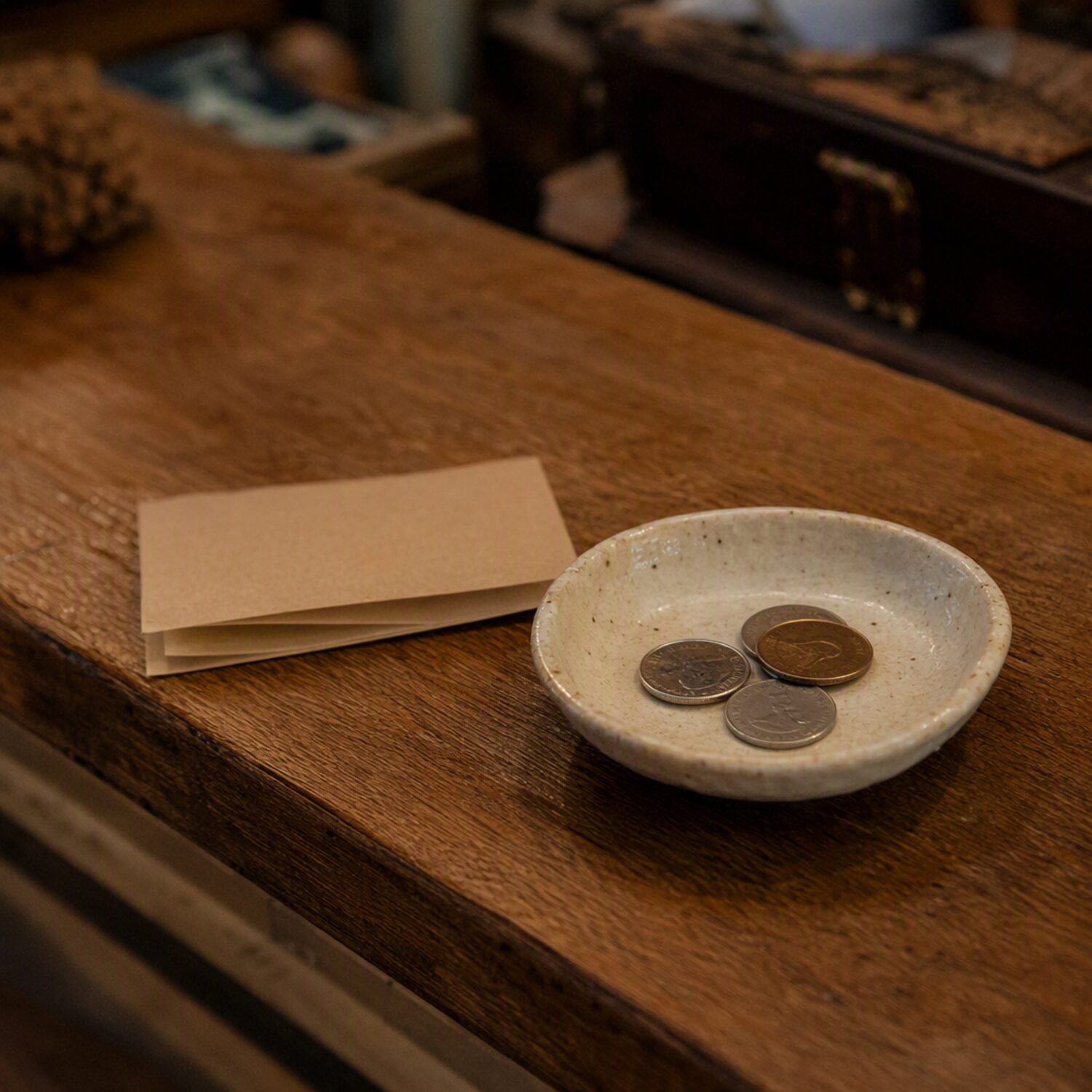 A ceramic dish with coins on a counter