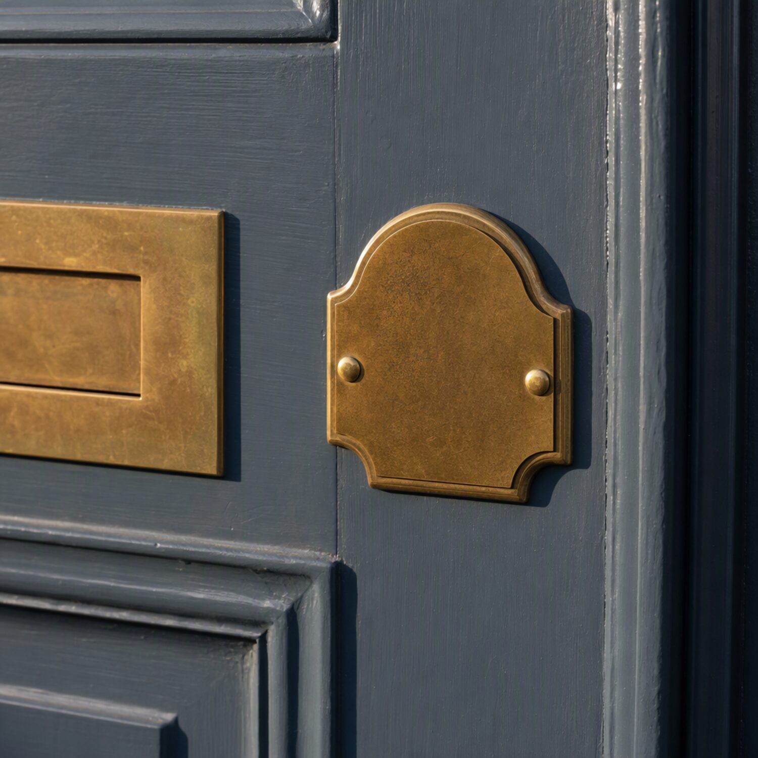 A brass number plate on a painted door
